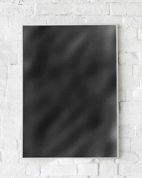 Sort abstrakt plakat med minimalistisk design hængende på hvid murstensvæg.